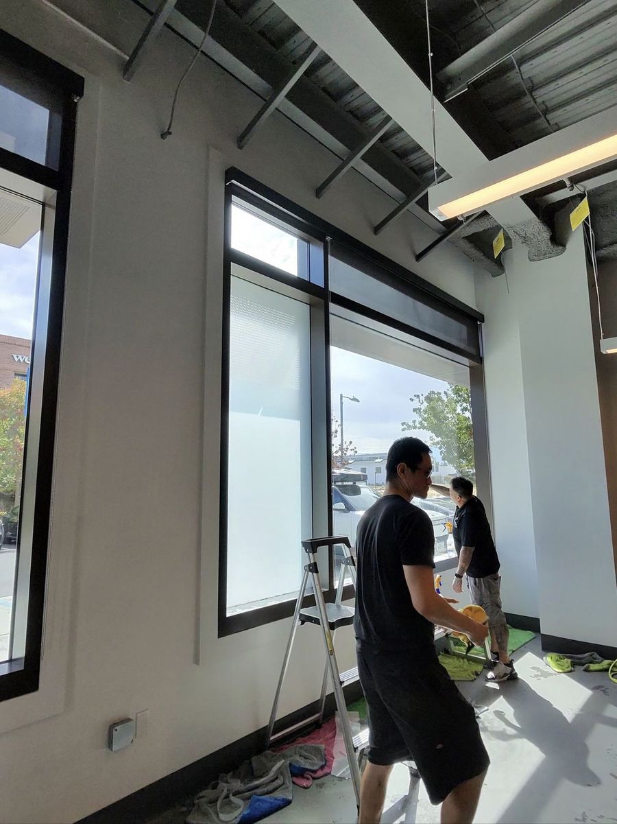 Installer applying frost film to office glass in Palo Alto