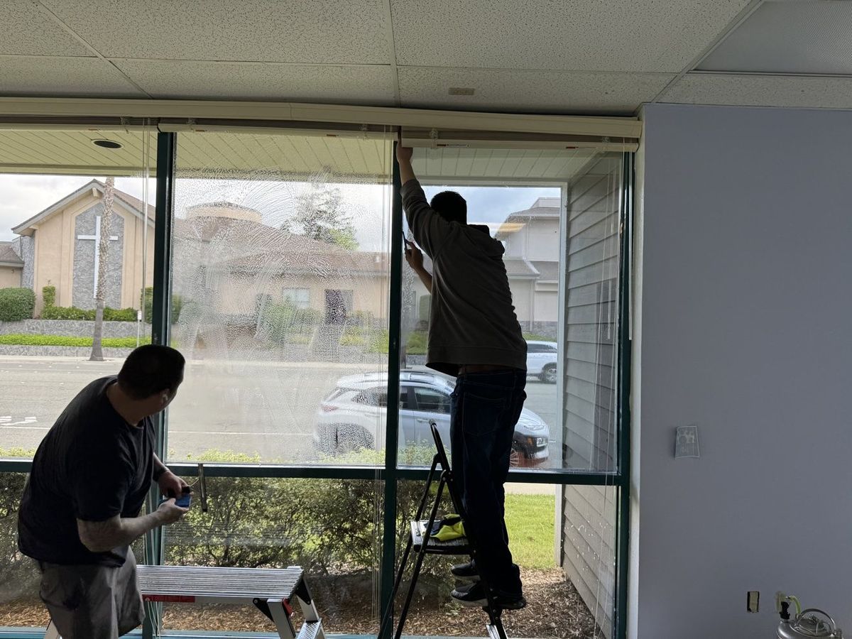 Installers applying reflective film inside a Milpitas commercial suite