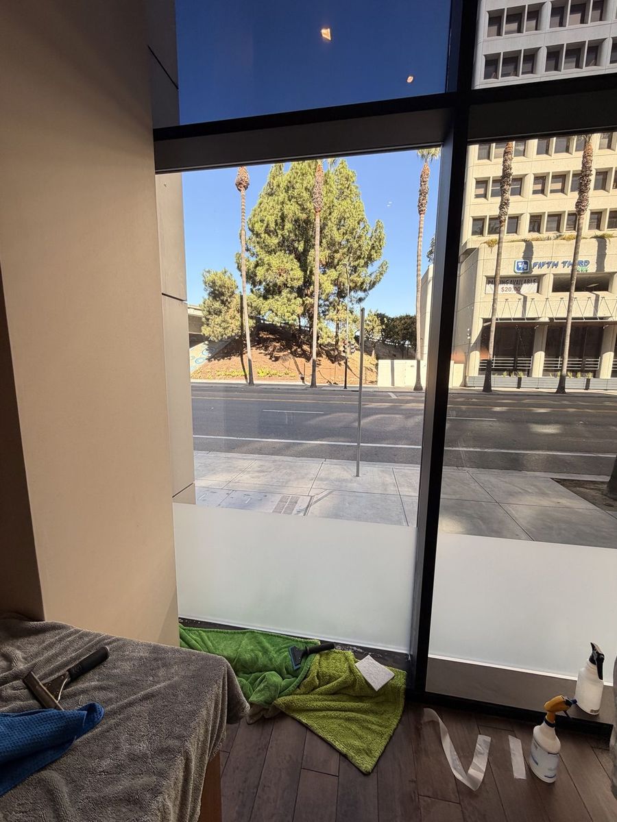 Installer applying tint to upper windows in a San Jose office
